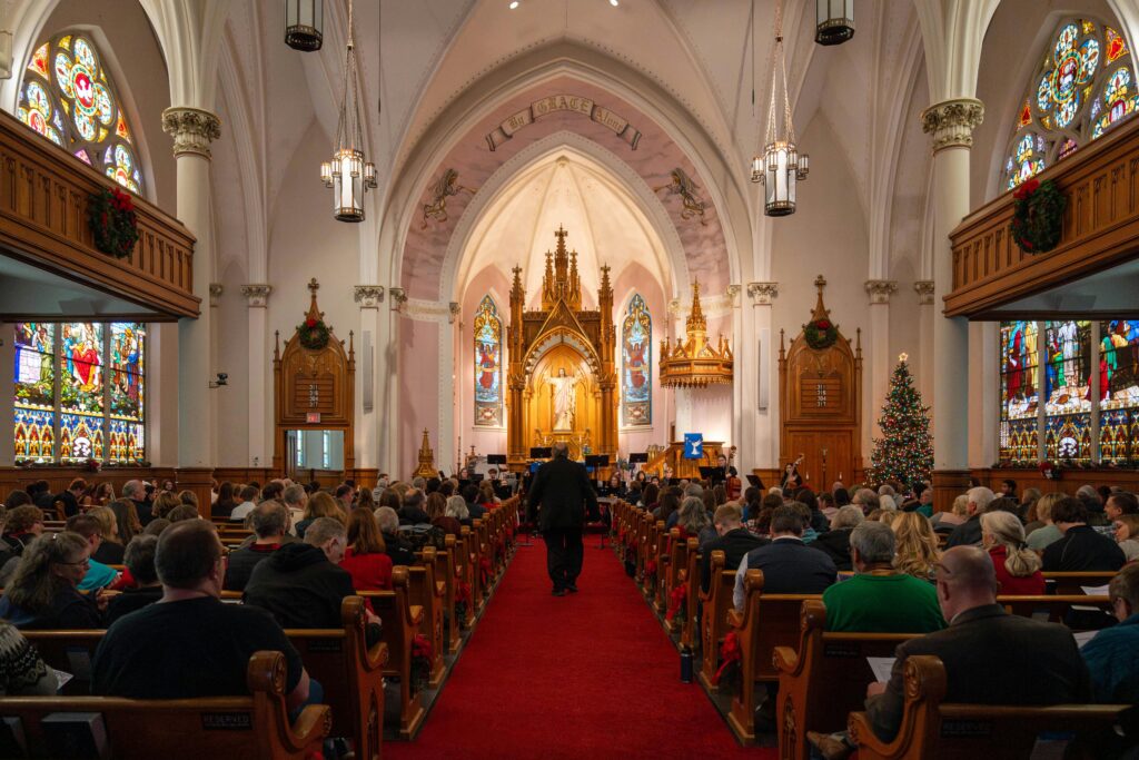 Beautiful Christmas service inside a historic cathedral with stained glass and festive decorations.