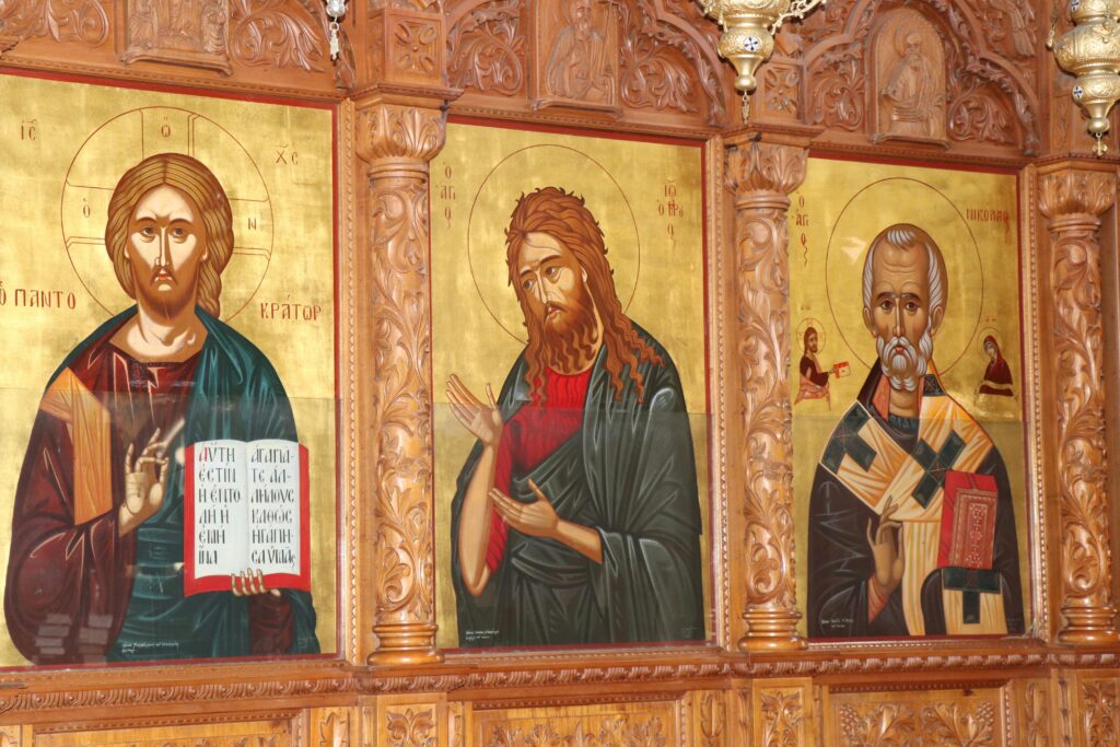 Who Is Jesus Christ? A Simple Biblical Explanation for Beginners Detailed traditional religious icon paintings on a wooden church wall.